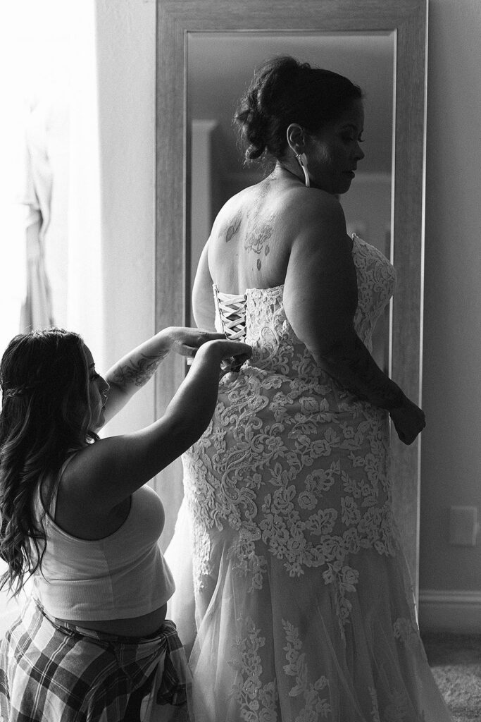 Bride getting her corset wedding dress on 