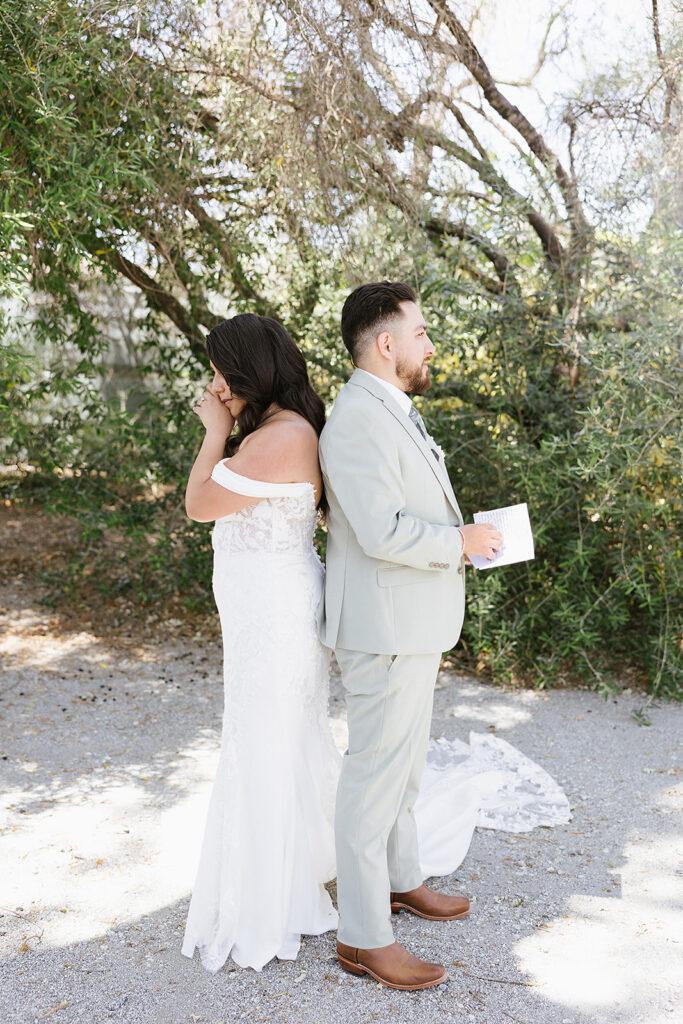 Bride and groom first touch and reading their vows while bride crys